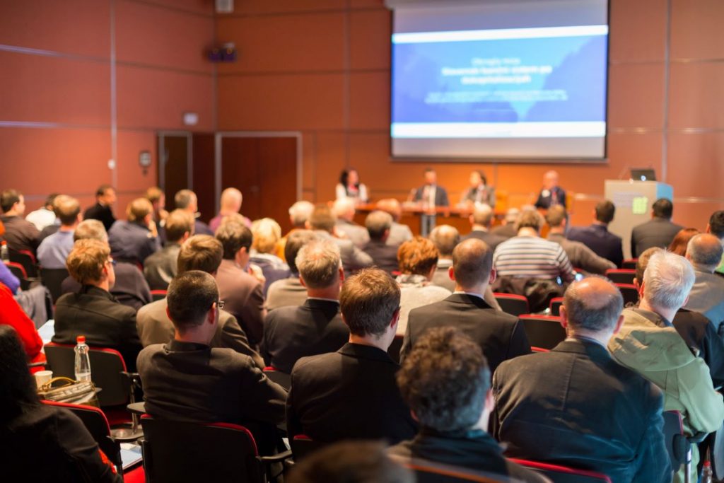 Audience of Students and Professors at a Security Symposium at a University